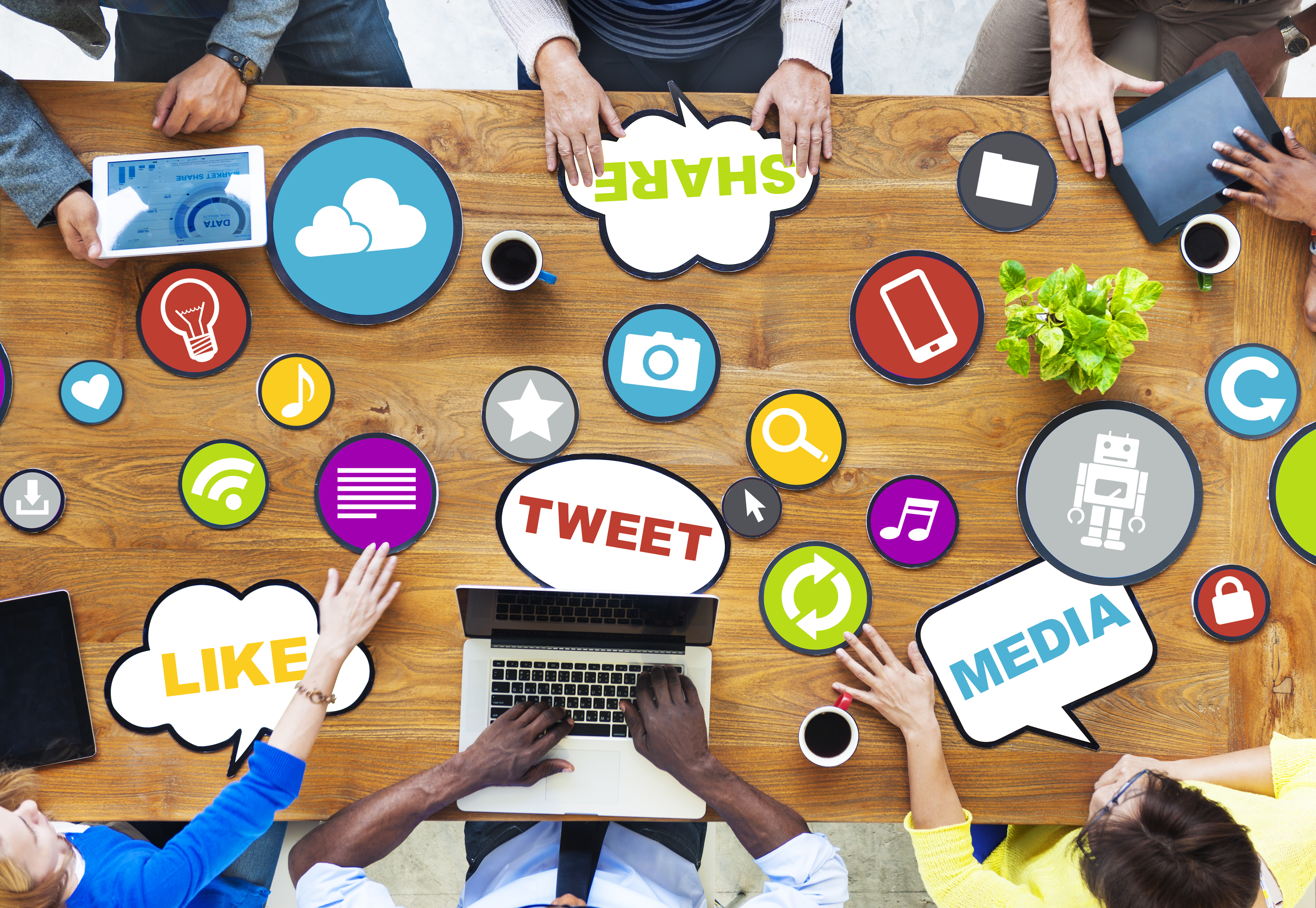 Group of people working at table with social media buzz words.